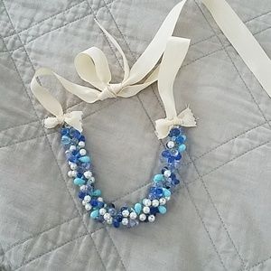 Blue bead necklace with cream ribbon tie